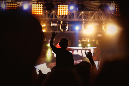 Black silhouette of young girl on rock concert, openair fest partyの写真素材