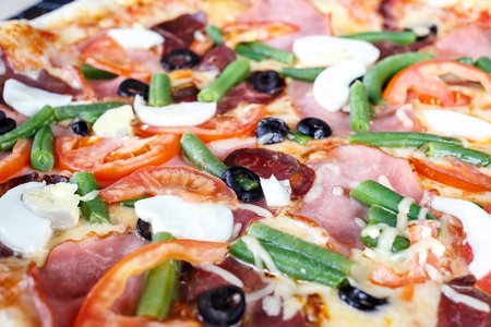 Close-up of Delicious Fresh Pizza with beans, cheese, ham and eggsの写真素材