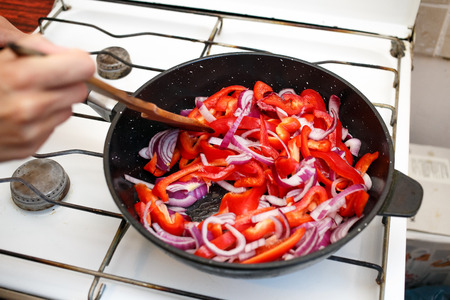 Fresh vegetables, peppers and onions in a frying pan, cooking food at home soviet union kitchenの写真素材
