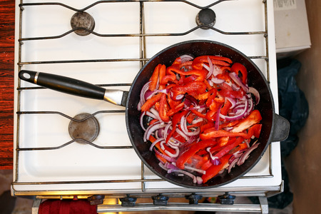 Fresh vegetables, peppers and onions in a frying pan, cooking food at home soviet union kitchenの写真素材