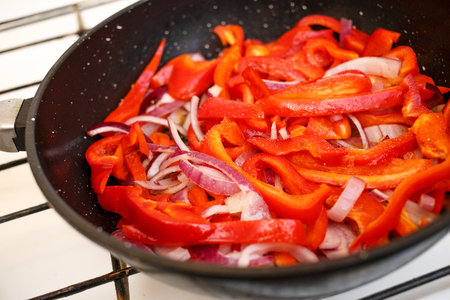 Fresh vegetables, peppers and onions in a frying pan, cooking food at home soviet union kitchenの写真素材