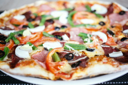 Close-up of Delicious Fresh Pizza with beans, cheese, ham and eggsの写真素材