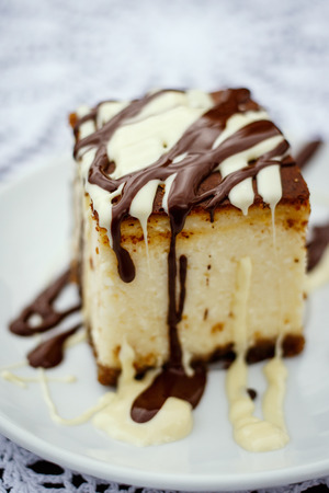 A slice of cheesecake with chocolate sauce, selective focusの写真素材
