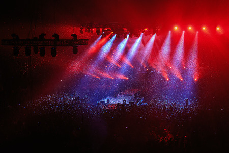 Concert stage and lighting background, red and blue lights, confetti over the crowdの写真素材