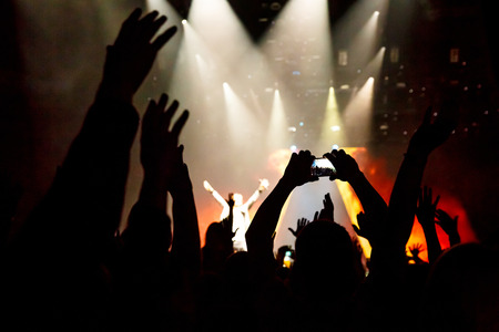 Take photo by smartphone in front of concert stage, during the light showの写真素材