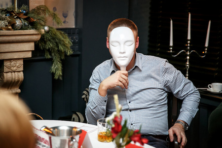 Playing Mafia with masks in a dark roomの写真素材
