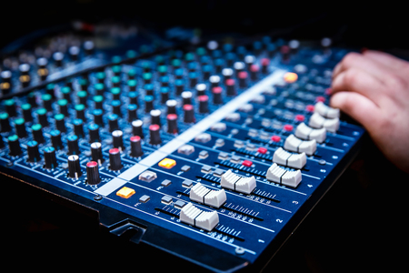Sound manager is working on the audio mixer, preparing new mix of a song or work on live eventの写真素材