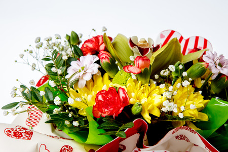closeup of colorful spring flowers bouquet on white background. red roses, white daisy. Side viewの写真素材