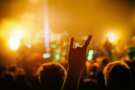 cheering crowd at a rock concert, hand with Sign of the hornsの写真素材