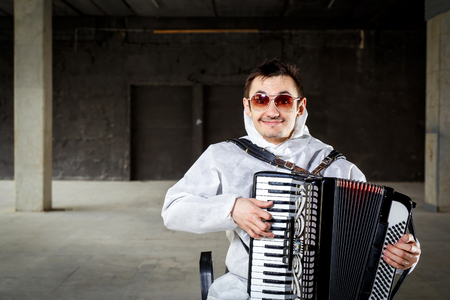 The musician playing the harmonica, accordion in the dark hallの写真素材