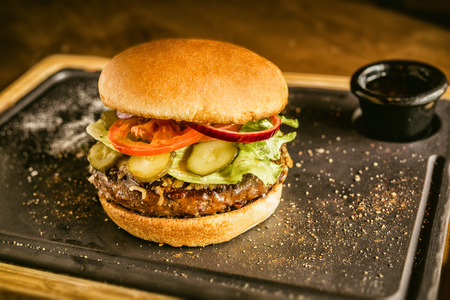 Burger full face with vegetables, spices and fries. Meat hamburger.の写真素材