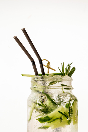 A cool drink of Mojito in Jar with a straw on the table. White backdroundの写真素材