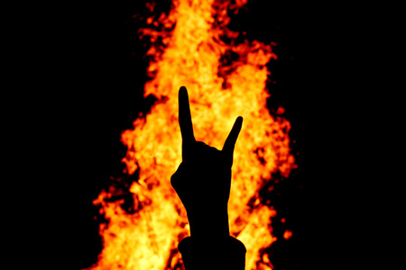 Silhouette of Rock and Roll hand sign against the fire background.の写真素材