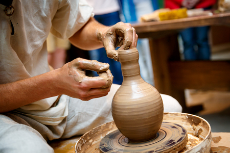 Hands working on pottery wheel, making a vaseの写真素材