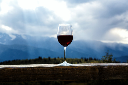 Glass of red wine and mountains on backgroundの写真素材