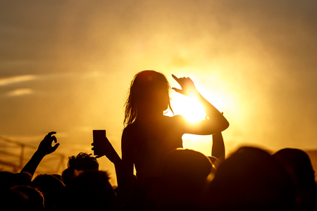 Girl cheering at outdoor music, rock festivalの写真素材