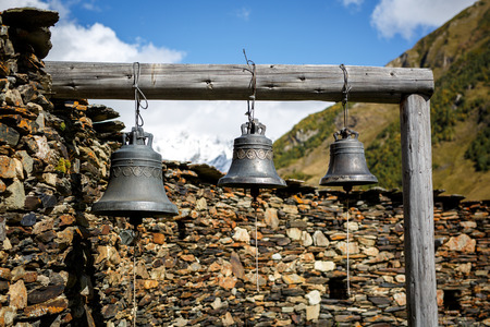 Closeup view of bells with patterns on a wooden beam. Mountains on the background.の写真素材