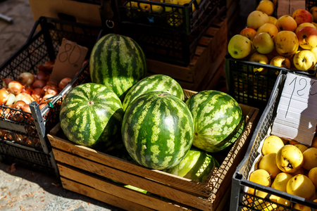 Pile of fresh ripe watermelons lying in wooden boxes in stret marketの写真素材