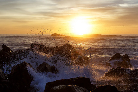 Sea waves crashing onto the rocks on sunset, Pacific Coastの写真素材