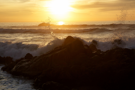 Sea waves crashing onto the rocks on sunset, Pacific Coastの写真素材