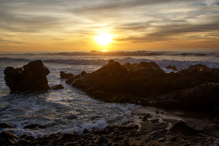 Sea waves crashing onto the rocks on sunset, Pacific Coastの写真素材