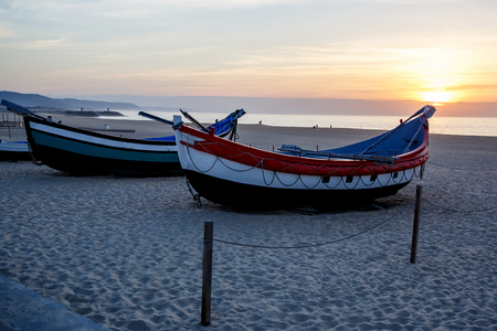 fishing boat on the beach at sunset, Nazare, Portugalの写真素材
