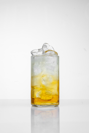 Glass with juice and ice on the white background.の写真素材