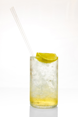 Glass of cocktail with ice and lemon isolated on white background, with reflectionの写真素材