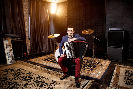 Accordionist in the recording studio. Accordion on the kneeの写真素材