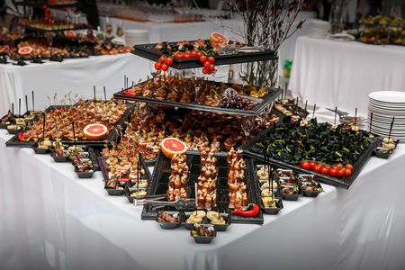 Many snacks on event catering. Canape, vegetables and fruits.の写真素材