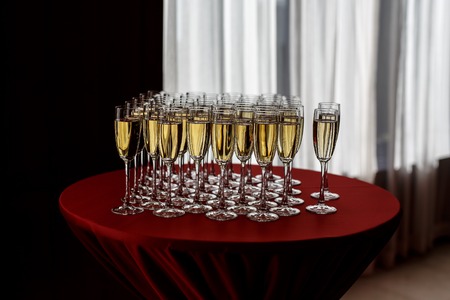 Champagne glasses standing on round table at the event partyの写真素材