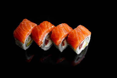Four classic sushi with salmon. Top view, black backgroundの写真素材