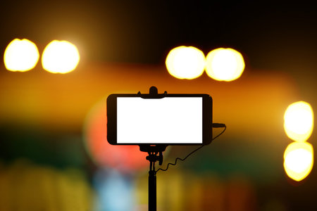 Smartphone on selfie monopod stick. Concert backgroundの写真素材