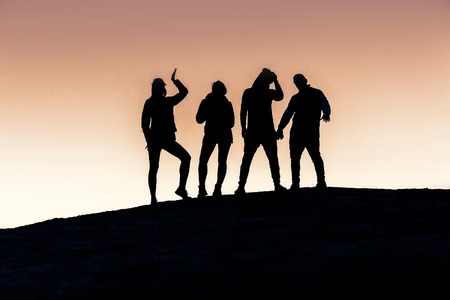 Silhouettes of five young people, group of friendsの写真素材
