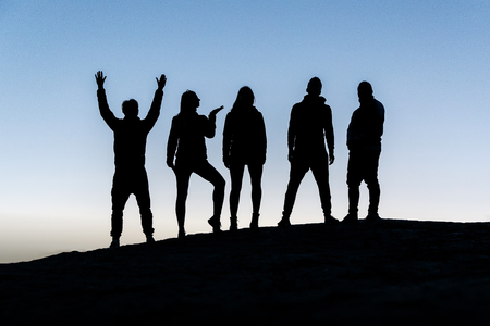 Silhouettes of five young people, group of friendsの写真素材