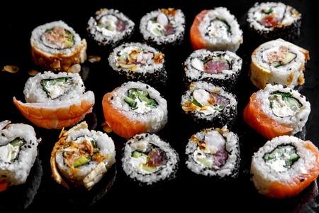 Japanese traditional sushi rolls with with different fillings. Top view, black backgroundの写真素材