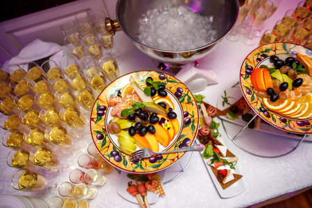 Fruits and glasses with champagne on the table before the event. Top viewの写真素材