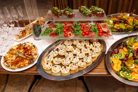 Beautifully decorated catering banquet table with different food snacks and appetizers on corporate, christmas, birthday, party, event or wedding celebrationの写真素材