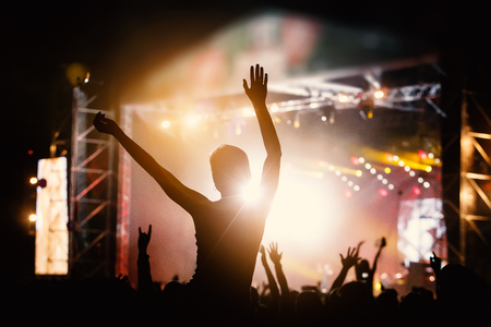 Photo of a crowd, people enjoying rock concert, raised up hands and clapping of pleasure, active night life concept.の写真素材