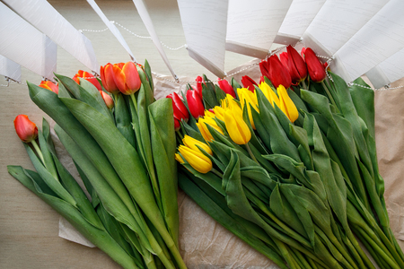 Colorful fresh tulip flowers on the windowsill near the blinds. Flowers for mother's day or women's dayの写真素材