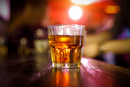 Glass of whiskey on the bar backgroundの写真素材