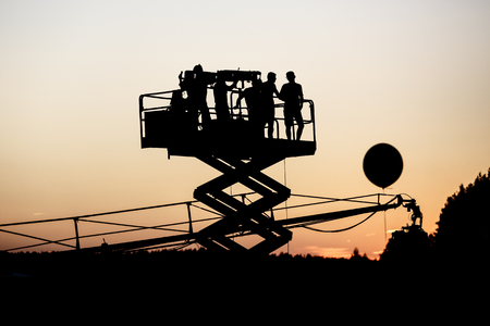 Silhouette of group of cameramen on the lift at a summer event, concertの写真素材