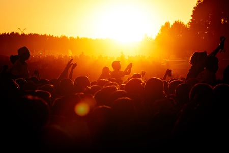 Crowd dancing on the summer party. Low sun orange light. Sunsetの写真素材