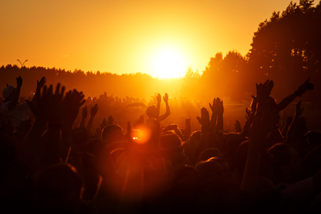 Crowd dancing on the summer party. Low sun orange light. Sunsetの写真素材