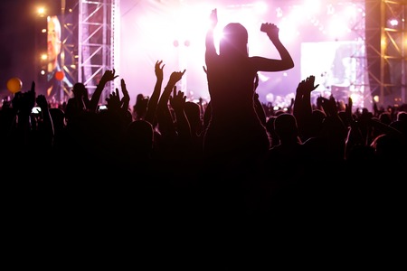 Silhouette of a crowd and girls opposite the scene at the summer music festivalの写真素材