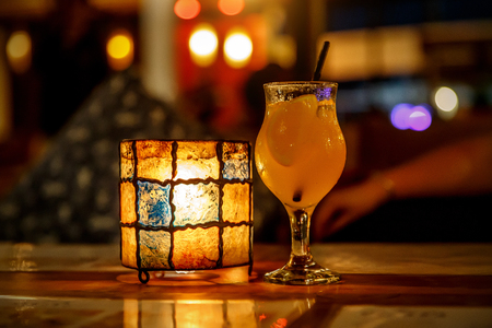 Orange cocktail at the bar. Tulip glass and lampの写真素材