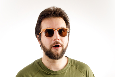Advertising portrait of a man. Sunglasses and a green T-shirt. Emotion of wonder, surpriseの写真素材