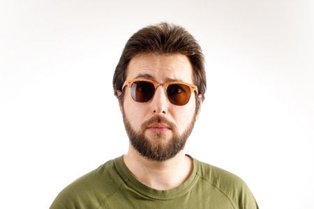 Advertising portrait of a man. Sunglasses and a green T-shirt. Emotion of wonder, surpriseの写真素材
