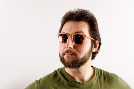 Advert portrait of a young man in sunglasses. Wary emotion, discontent on faceの写真素材