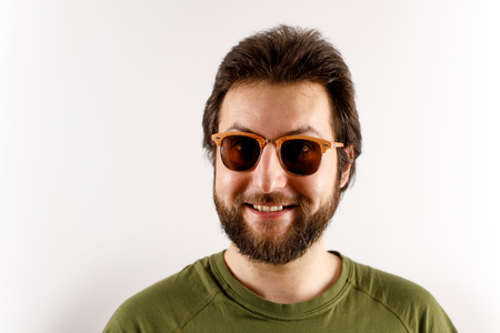 A man in sunglasses and a green shirt is smiling at the camera.の写真素材